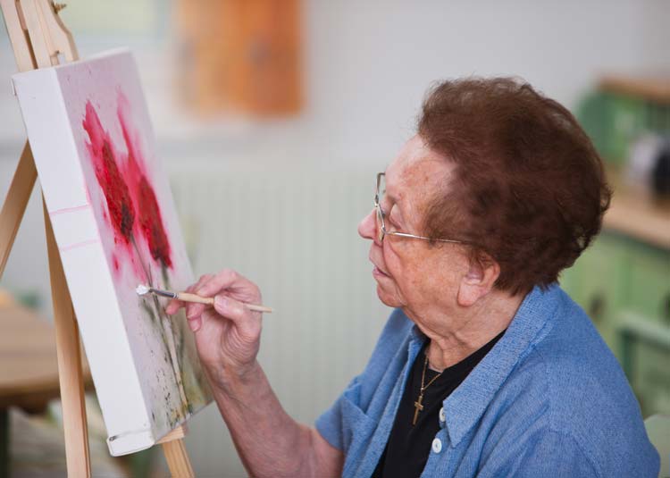 Ältere Frau beim Malen