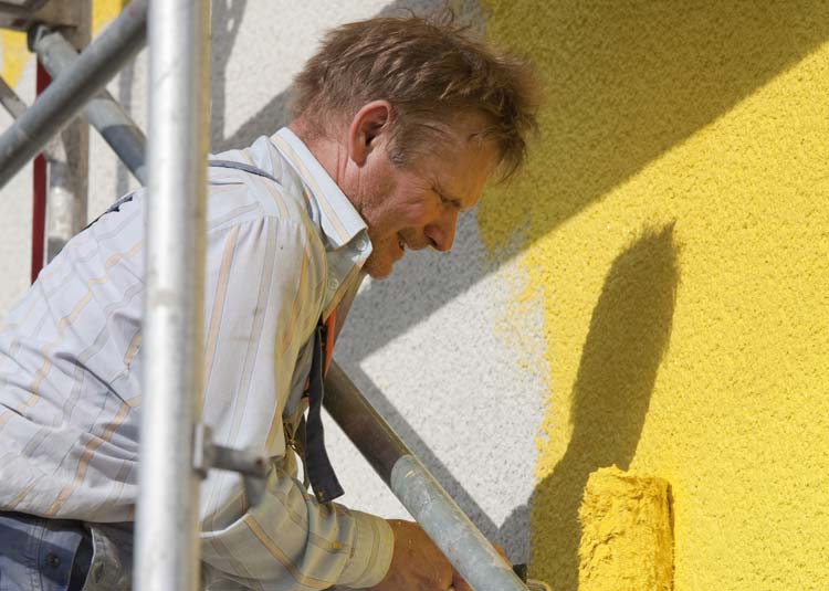 Maler beim Streichen einer Fassade