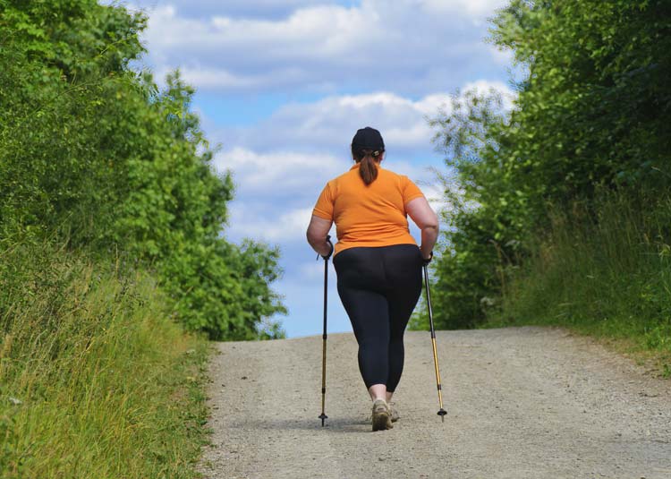 Übergewichtige Frau beim Wandern
