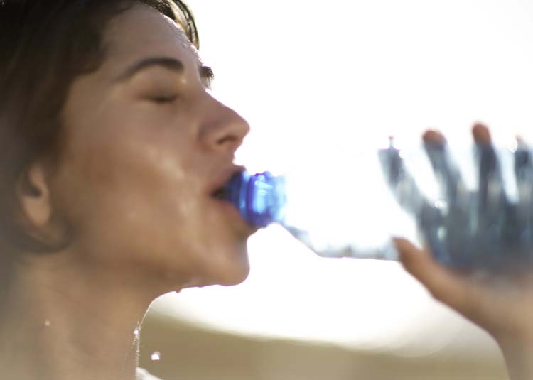 Frau trinkt aus Wasserflasche