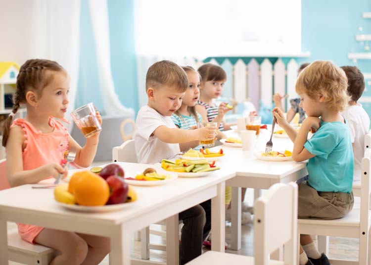 Kinder beim gemeinsamen gesunden Essen in der Kita