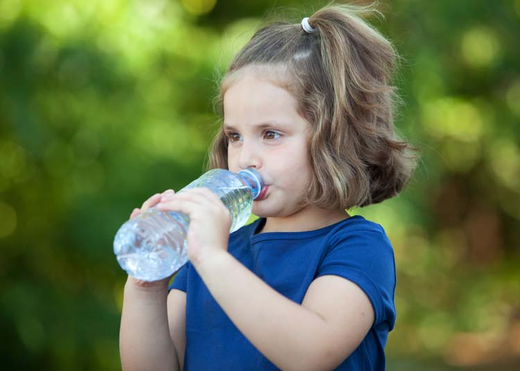 Kleines Mädchen trinkt Wasser aus Flasche